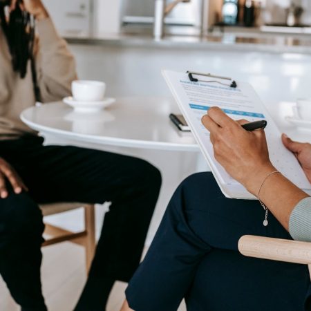 Crop faceless multiethnic interviewer and job seeker going through interview